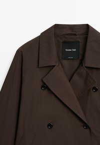 Brown double-breasted coat made of smooth fabric, featuring a notched collar and black buttons. Label reads "Massimo Dutti."