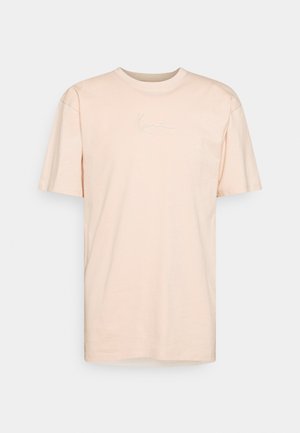 Pale pink, rövid ujjú póló, puha pamutból készült, világos színű dombornyomott logóval a mellrészen. Klasszikus kerek nyakkivágás.