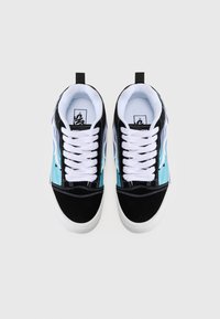 Sorte og turkise sneakers med hvite snører, laget av semsket skinn og lerret, med søm detaljer og en løkke for å dra i hælen.