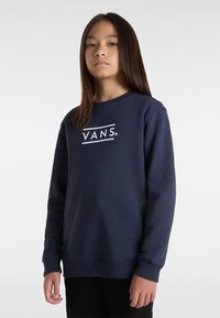 La felpa blu navy presenta un colletto rotondo, maniche lunghe e un logo bianco "VANS" in un audace design grafico sulla parte anteriore.
