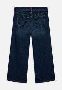 Jeans a gamba larga blu scuro con una texture liscia, dotati di due tasche posteriori e cuciture a contrasto lungo la vita e le tasche.