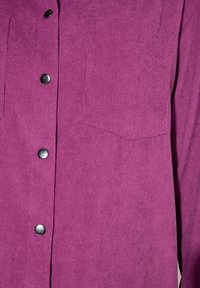Camicia in costina viola con chiusura a bottoni sul davanti, due tasche sul petto e bottoni neri, che presenta una texture a coste e una finitura liscia.