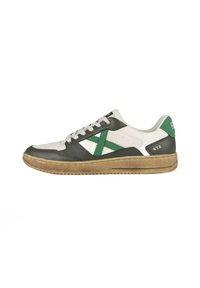 Sneaker con tomaia in pelle bianca e verde scuro, con un motivo a croce verde testurizzato, lacci bianchi e suola in gomma marrone.