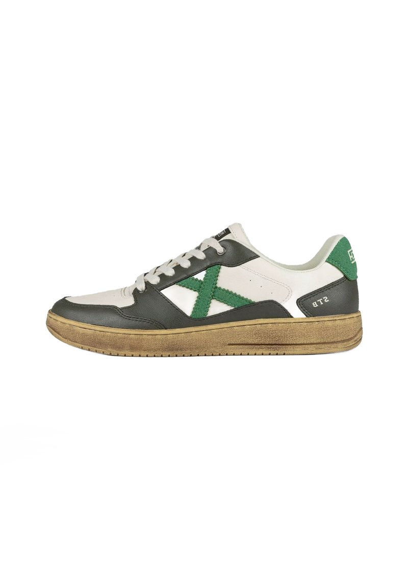 Sneaker con tomaia in pelle bianca e verde scuro, con un motivo a croce verde testurizzato, lacci bianchi e suola in gomma marrone.