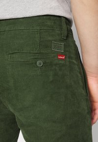 Levi's® XX CHINO SLIM TAPER PANTS - Chinos - mossy green 14w cord gd
