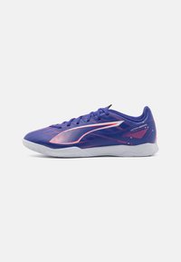 Fioletowe buty sportowe z teksturowanym wzorem, z różowymi akcentami i białą podeszwą. Lekkie materiały i niskoprofilowa sylwetka.