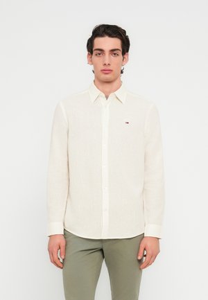 Svetlá košeľa na zapínanie z ľanu, s voľným strihom, dlhými rukávmi a malou nášivkou s logom na hrudi.