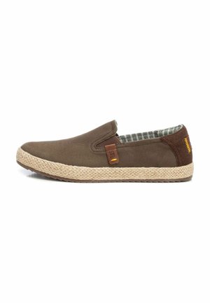 Zapatos de lona marrones sin cordones con suelas de yute tejidas, que cuentan con un forro de tela a cuadros y una pequeña etiqueta de cuero en el lado.