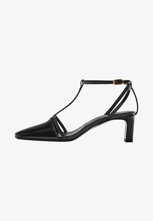 Chaussure à talon haut en cuir verni noir avec un bout pointu, une bride à la cheville et un petit talon carré. Présente deux fines bandes avant pour le design.