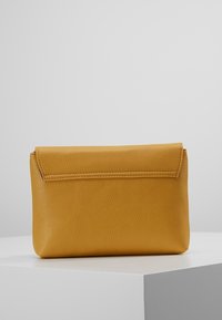 Borsa a pochette gialla in pelle con superficie texture e chiusura a pattina. Forma rettangolare compatta, design minimalista.