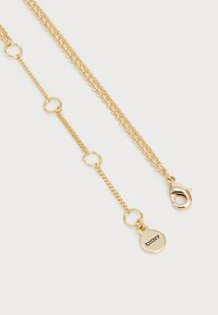 Collana a catena di colore oro con una combinazione di anelli a forma di sfera liscia e anelli piatti, dotata di chiusura a granchio e di un'etichetta DKNY.