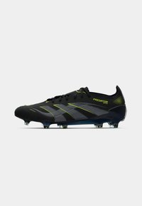 Black soccer cleat with a textured upper, featuring gray and neon green stripes, a low profile design, and transparent conical studs.