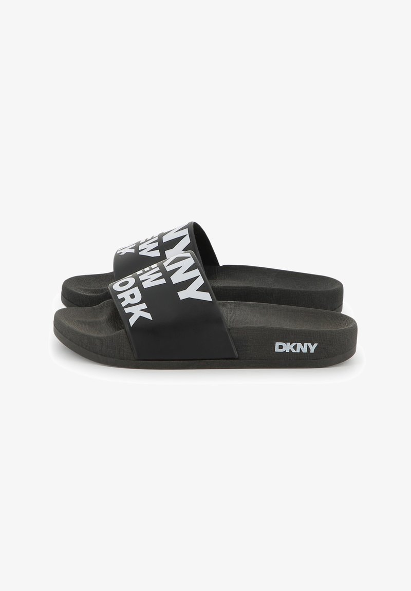 Chanclas negras de goma con correas anchas y el texto blanco del logo DKNY. Plantilla y suela negras texturizadas para mayor agarre.
