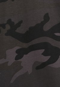 Mørkt kamuflasjemønster på myk tekstil, med varierende nyanser av svart og grått, med abstrakte former og subtil tekstur.