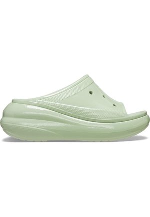 Zoccoli verde chiaro con finitura lucida, dotati di fori di ventilazione e di una fascia testurizzata. Il design è ampio con bordi arrotondati.