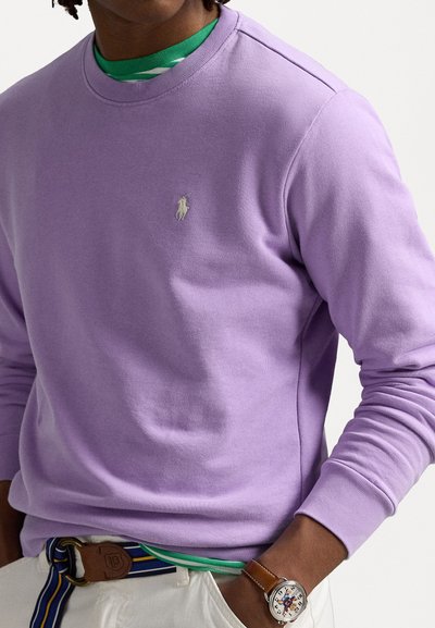 Sweatshirt lilás claro feito de algodão liso, com decote redondo e punhos canelados, apresentando um pequeno logótipo bordado no peito.