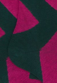 Tessuto lavorato a maglia con un motivo geometrico di un vivace rosa e verde scuro, con una texture a coste e una finitura liscia.