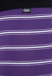 Lila gestreifter Stoff mit dünnen weißen Linien, glatte Textur, mit einem schwarzen Band und einem "Buffalo"-Logoschild oben.