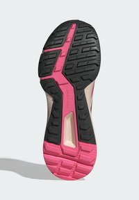 Suela de zapato con patrón de tracción de goma negra, acentos rosas y áreas texturizadas. Presenta ranuras para agarre y estabilidad en diversas superficies.