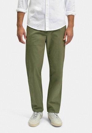 Olivengrønne chinos lavet af bomuldsblanding, med lige ben, der har sidelommer og en glat tekstur, parret med lyse sneakers.