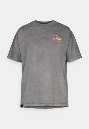 Grijze katoenen t-shirt met korte mouwen. Heeft een ronde halslijn en een oranje "City" tekstgrafiek op de linkerborst. Zachte textuur.