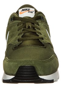 Gröna Nike Air sneakers med överdel i mocka och mesh, runda snören, vit Swoosh-logga, svart sula och vadderad krage.