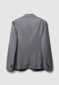 Giacca blazer grigia vista da dietro con maniche lunghe, colletto a punte e quattro bottoni neri su ciascun polsino.