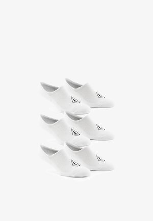 Kuusi paria valkoisia näkymättömiä sukkia, jotka on järjestetty kolmeen pinoon, jokaisessa pikku musta geometrinen logo päällä edessä.