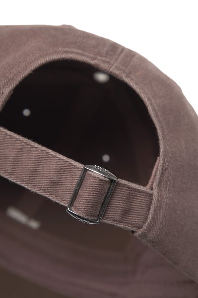 Brun tygkeps med böjd skärm, med ett justerbart spänne i metall baktill och cirkulära ventilationshål på insidan.