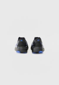 Chaussures de sport noires avec des accents bleus, dotées d'une texture lisse et d'un talon arrondi. Le design inclut des rayures discrètes et un logo à l'arrière.