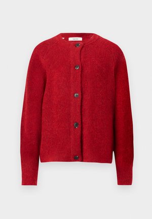 Punainen neulecardigan, jossa on pyöreä pääntie, täysimittaiset hihat ja kuusi mustaa nappia edessä. Pehmeä rakenne, joka on hieman löysä.
