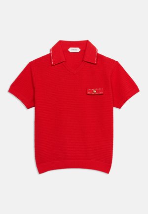 Polo rouge à manches courtes en maille avec motif texturé, col avec surpiqûres blanches et petite poche avec bouton sur la poitrine.