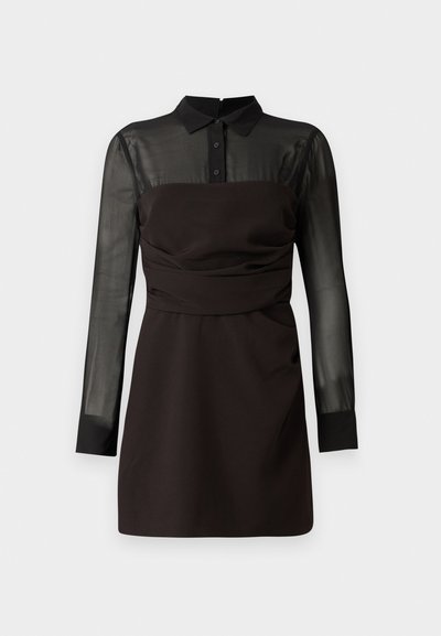 Vestido preto com topo em rede preta transparente e mangas longas, gola com botões e detalhes franzidos na cintura. Acabamento em tecido suave.