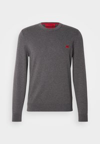 Pull à manches longues gris foncé à col ras du cou avec poignets et ourlet côtelés, petit logo rectangulaire rouge sur la poitrine gauche, et détail intérieur du col rouge.