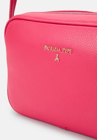 Borsa a tracolla in pelle rosa con superficie texturizzata, logo dorato con la scritta "PATRIZIA PEPE" e un accento dorato sotto il logo.