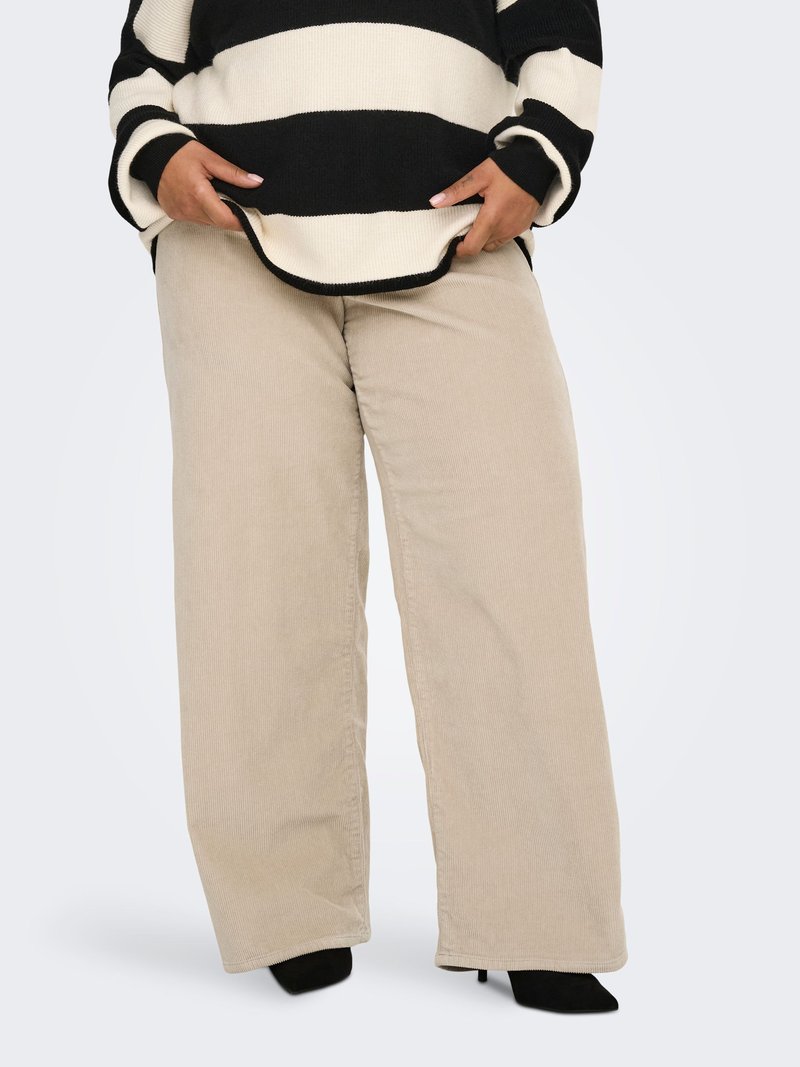 Beežikarva laiade säärega sametist püksid vertikaalsete soontega, kombineeritud must-valgete triibuliste üle suurte kampsuniga, millel on soonikkoes varrukapaelad.