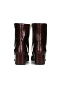 Botas de tobillo burdeos hechas de cuero brillante, con tacón cuadrado, cremalleras laterales y una textura suave con sutiles detalles de costura.