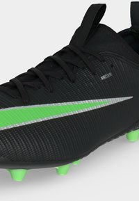 Μαύρο ποδοσφαιρικό παπούτσι Nike με πράσινη και ασημί σήμανση, μαύρα κορδόνια και πράσινα τακούνια στη σόλα, με υλικό ανώτερου μέρους Nikskin με υφή.
