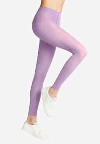 Leggings di lavanda chiaro con una texture liscia e elasticizzata, che mostrano un design aderente. Abbinati a sneakers bianche, enfatizzando uno stile casual.