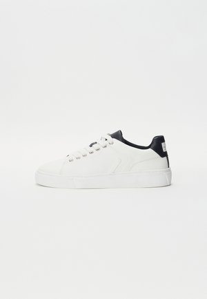 Vita sneakers med övre i slät läder, svarta hälaccenter, rund tå och snörningsdesign. Tjock vit sula med texturerat mönster.