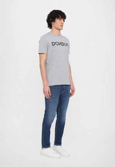 Grå bomulls t-skjorte med svart "DONDUP" logo, kombinert med mørkeblå jeans og hvite joggesko. Enkelt design og avslappet passform.
