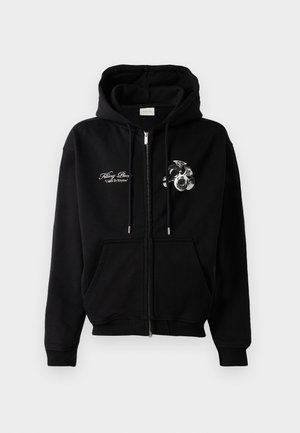 Zwarte rits hoodie met trekkoorden, voorzien van witte schrift tekst "Filling Piece United By Rhythm" en een trompetcluster grafiek op de borst.