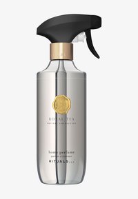 Bottiglia spray in vetro trasparente con un grilletto nero opaco, dettagli in metallo dorato e un'etichetta con il testo "Royal Tea" e "profumo per la casa".