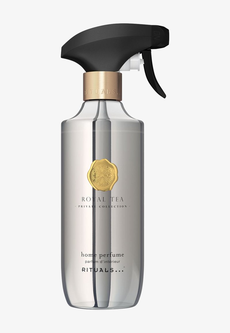 Bottiglia spray in vetro trasparente con un grilletto nero opaco, dettagli in metallo dorato e un'etichetta con il testo "Royal Tea" e "profumo per la casa".