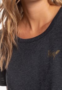 Grå bomulds t-shirt med rund halsudskæring, der har et lille guld "Roxy" logo på venstre brystområde og korte ærmer.