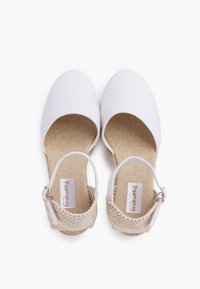 White canvas shoes with a round toe and a textured beige ankle strap featuring a buckle. Smooth fabric and a soft inner lining.