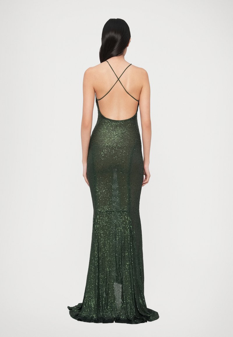Figursydd mörkgrön klänning med en glittrande textur, låg rygg och korslagda band, med en utsvängd nederkant.