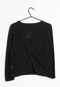 Schwarze Strickjacke mit einem Spitzenmuster auf der Rückseite und einem einfarbigen Vorderteil. Lange Ärmel und ein runder Ausschnitt, befestigt an einem schwarzen Haken.