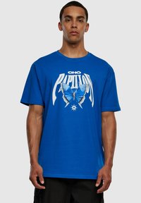Camiseta de algodón azul con un estampado gráfico de una mariposa y texto, mangas cortas y escote redondo.