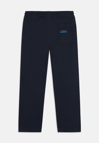 Navy blue jogger pants made from soft fabric, featuring an elastic waistband, straight cut, and a single back pocket with a logo.